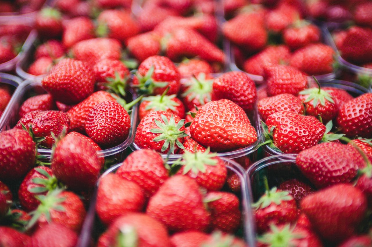 Vibrant red strawberries in containers showcasing fresh and healthy fruit.